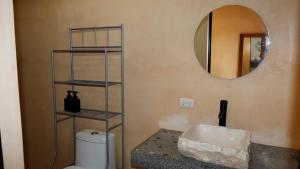 ein Badezimmer mit Toilette und Spiegel in der Unterkunft Habitación 3 Casa Eve in Brisas de Zicatela