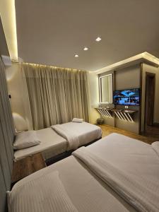 a hotel room with two beds and a flat screen tv at Sheraton Ocean 7-PRIVATE SUITES - Without Pool access in Cairo +42 photos
