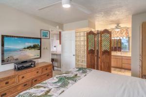 维雷亚Haleakala Shores A-302的一间卧室，里面有一张床和一台平板电视