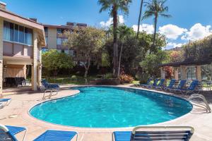 维雷亚Haleakala Shores A-302的一个带椅子的大型游泳池和一栋建筑