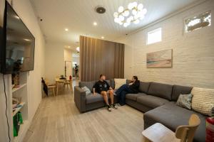 two people sitting on a couch in a living room at Urban Nomad Potts Point - 18 to 39 only in Sydney +33 photos