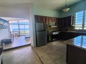 a kitchen with a stainless steel refrigerator and a balcony at Sky House in Rincon
