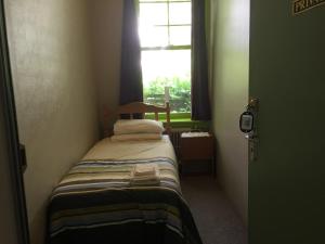インバーカーギルにあるLovett Lodgeの窓のある部屋にある小さなベッド