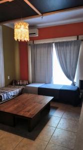 a bedroom with two beds and a table and a chandelier at Casa Il cuore felice in San Rafael +2 photos