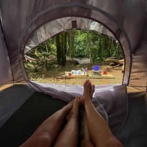 een persoon die op zijn voeten ligt in een tent bij Eco Camping do Véu in Majé