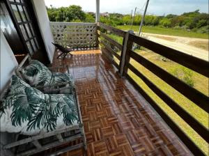 a porch with a bed and a fence at CASA PARA 10 PERSONAs in Aguas Dulces