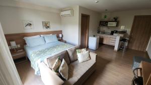 a bedroom with a bed and a couch in a room at Pedra Azul - Flat Particular in Pedra Azul