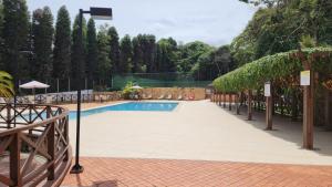 a swimming pool in a yard with a fence at Pedra Azul - Flat Particular in Pedra Azul