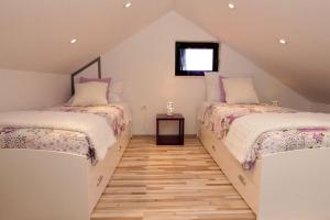 a attic bedroom with two beds and a wooden floor at Family friendly house with a swimming pool Bol, Brac - 23787 in Bol