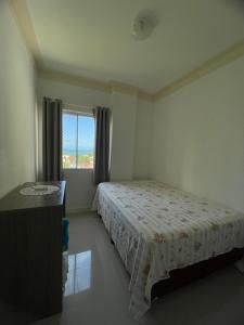 un dormitorio con una cama y una ventana en Apartamento com vista mar, en Porto Belo
