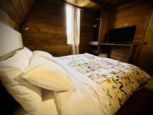 a bed in a bedroom with a wooden wall at La Encantada Cabañas in Cajamarca