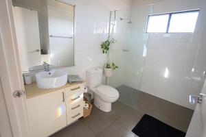 a bathroom with a toilet and a sink and a mirror at Suburban Sanctuary South Hedland in South Hedland +16 photos