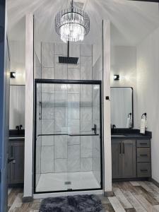 a shower with a glass door in a bathroom at New Cougar Cabin with Air Hockey in Purcell