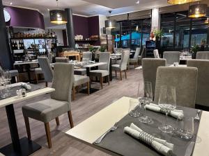 a restaurant with tables and chairs and a bar at Logis Hôtel-Restaurant La Coupe d'Or in Lisieux