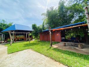 a small red building with a blue roof at HomeStay Tre Vàng in A Xiêm