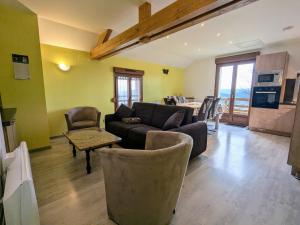 a living room with a couch and chairs and a kitchen at Charmante maison rénovée avec 3 chambres, garage, et animaux admis à Gerbamont - FR-1-589-161 in Gerbamont 