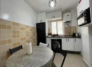 a kitchen with a table and a kitchen with a stove at El Jadida - Spacious 2 Bedroom Comfortable in El Jadida