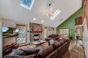 ein Wohnzimmer mit einem großen Sofa und einem Kamin in der Unterkunft Locust Lake Livin Hot Tubfire Pitskiingpets in Pocono Lake