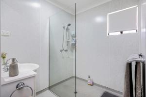 ein Badezimmer mit Dusche und Waschbecken in der Unterkunft 3 Bedroom Family-Friendly Coastal Haven! in Yeppoon + 21 Fotos