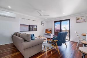 ein Wohnzimmer mit Sofa und Fernseher in der Unterkunft 3 Bedroom Family-Friendly Coastal Haven! in Yeppoon