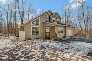 ein Haus mit einer Auffahrt im Schnee in der Unterkunft Locust Lake Livin Hot Tubfire Pitskiingpets in Pocono Lake