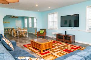 マートルビーチにあるTropical Cherry Grove Ocean View Beach House w Poolのソファと薄型テレビのあるリビングルーム