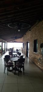 a dining room with tables and chairs and a brick wall at Flat 08B Monte Castelo, Gravatá in Sairé