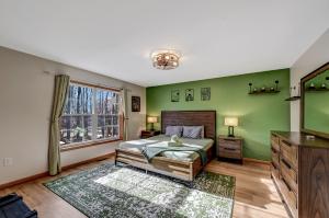 ein Schlafzimmer mit grünen Wänden, einem Bett und einem Fenster in der Unterkunft Locust Lake Livin Hot Tubfire Pitskiingpets in Pocono Lake