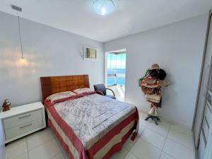 une chambre avec un lit, un bureau et une fenêtre dans l'établissement Apartamento de frente para o Mar, à Guarapari