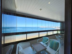 d'un balcon avec des chaises et une vue sur la plage. dans l'établissement Apartamento de frente para o Mar, à Guarapari