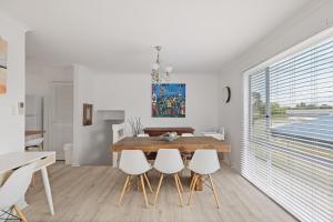 a dining room with a wooden table and white chairs at Cerulean Getaway in Cowes +8 photos