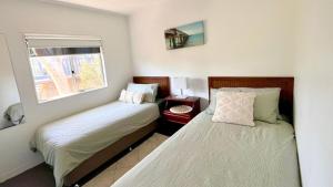 a bedroom with two beds and a window at SeaSong in Ventnor in Ventnor
