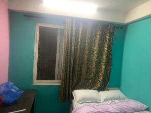 a bedroom with a bed and a window with curtains at Swoyambhu Home Stay in Kathmandu
