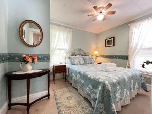 una camera con letto, specchio e tavolo di Strathaird Bed and Breakfast a Niagara Falls