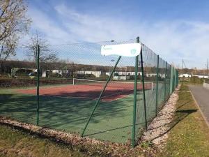 a tennis court with a net on a tennis court at Joli mobilhome 7 places, 3 chambres Blois Amboise Piscine in Onzain