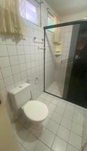un bagno bianco con wc e doccia di Casa de praia condomínio beira-mar praia de sonho verde alagoas n 9 a Paripueira