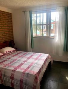una camera da letto con un letto e una finestra di Casa de praia condomínio beira-mar praia de sonho verde alagoas n 9 a Paripueira