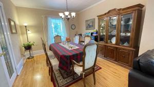 a dining room with a table and a china cabinet at Strathaird Bed and Breakfast in Niagara Falls