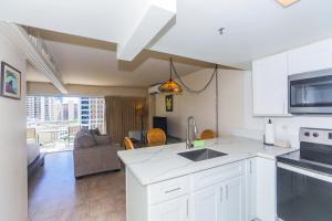 een keuken met witte kasten en een woonkamer bij Ilikai Tower 936 Lagoon View 1BR in Honolulu