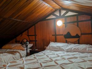 a bedroom with a bed and a wooden ceiling at La Cabaña de Ciela C glamping con jacuzzi , minigolf y croquet in Latacunga