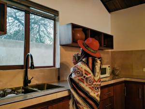 a person wearing a hat standing in a kitchen at La Cabaña de Ciela C glamping con jacuzzi , minigolf y croquet in Latacunga +18 photos