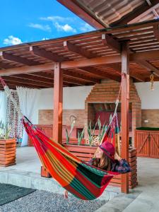 a woman laying in a hammock in a patio at La Cabaña de Ciela C glamping con jacuzzi , minigolf y croquet in Latacunga