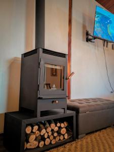 a woodburning stove in a room with a couch at La Cabaña de Ciela C glamping con jacuzzi , minigolf y croquet in Latacunga