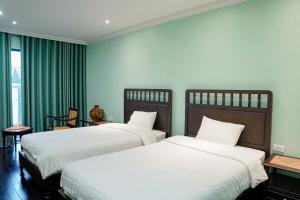 two beds in a hotel room with green walls at Homestay Art Bát Tràng in Kim Quan +16 photos
