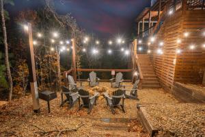 a patio with a table and chairs at night at Brand New Luxury Mountain Retreat Awaits You! in Broken Bow +38 photos