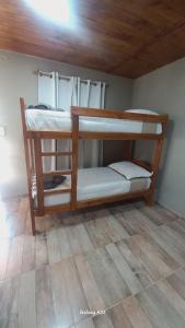 two bunk beds in a room with a wooden floor at Alojamiento Pytu'u Pora in Colonia Carlos Pellegrini