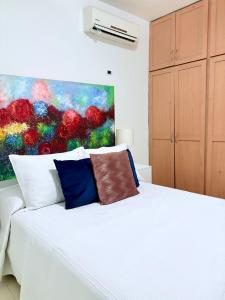 a bedroom with a white bed with a painting on the wall at Casa Privada 2hab San Pedro cerca consulado Americana in Monterrey +15 photos