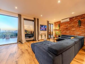 a living room with a couch and a brick wall at Modern villa with private swimming pool in Vrana