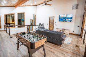 a living room with a couch and a foosball table at Brand New Luxury Mountain Retreat Awaits You! in Broken Bow