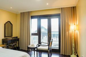 a hotel room with a bed and a desk and a window at Homestay Art Bát Tràng in Kim Quan